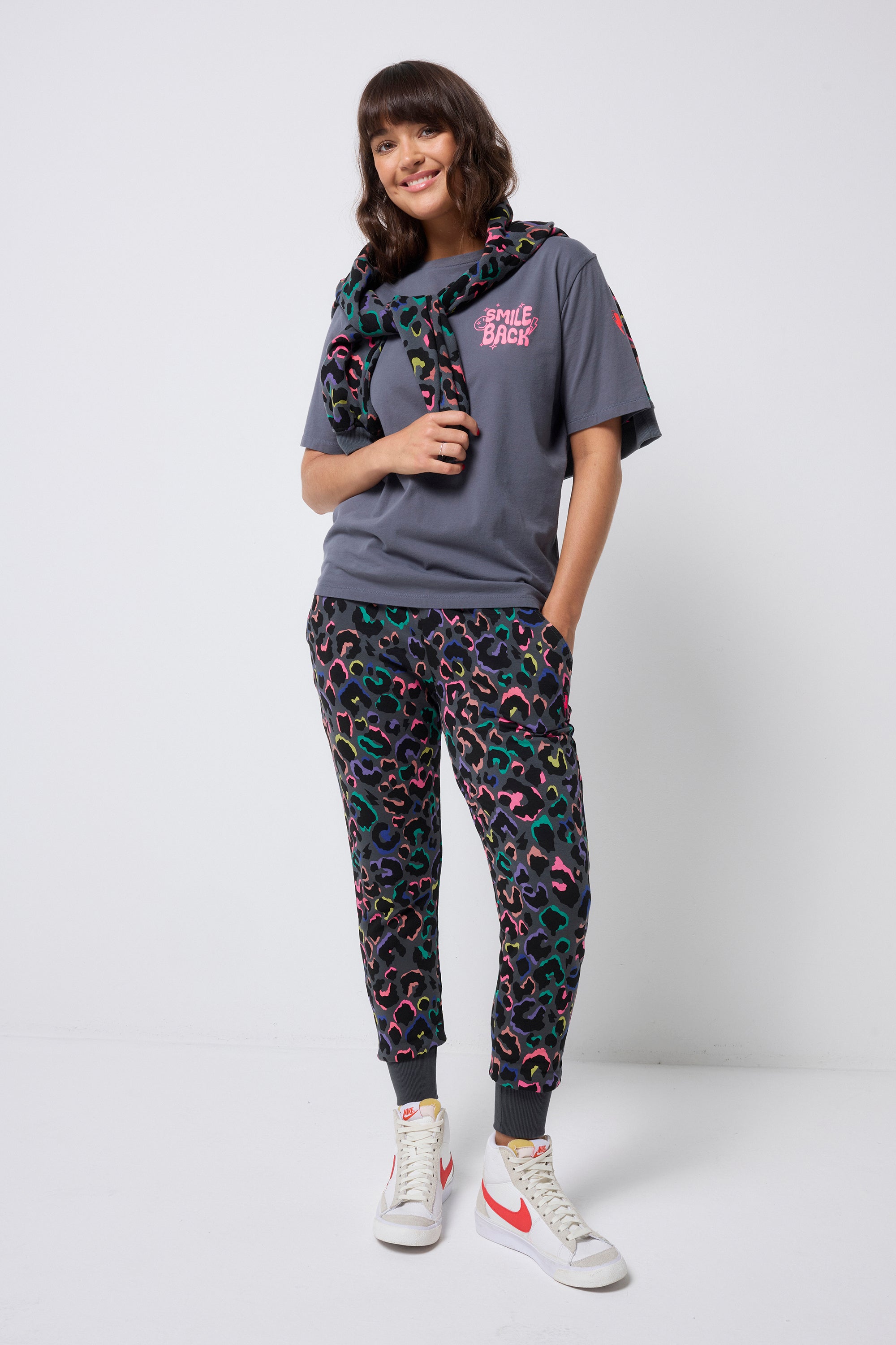 Scamp and Dude Grey with Rainbow Shadow Leopard and Lightning Bolt Cosy Joggers | Model wearing grey joggers featuring rainbow shadow leopard print paired with a grey t shirt.