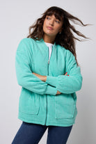 Scamp and Dude Turquoise Organic Cotton Quilted Lightning Bolt Oversized Bomber Jacket | Model wearing a white t-shirt with blue denim jeans and turquoise oversized bomber jacket.