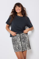 Scamp and Dude Grey Wild Cheetah Zip Front Denim Mini Skirt | Model wearing a dark grey studded t-shirt with a grey denim zip front mini skirt.