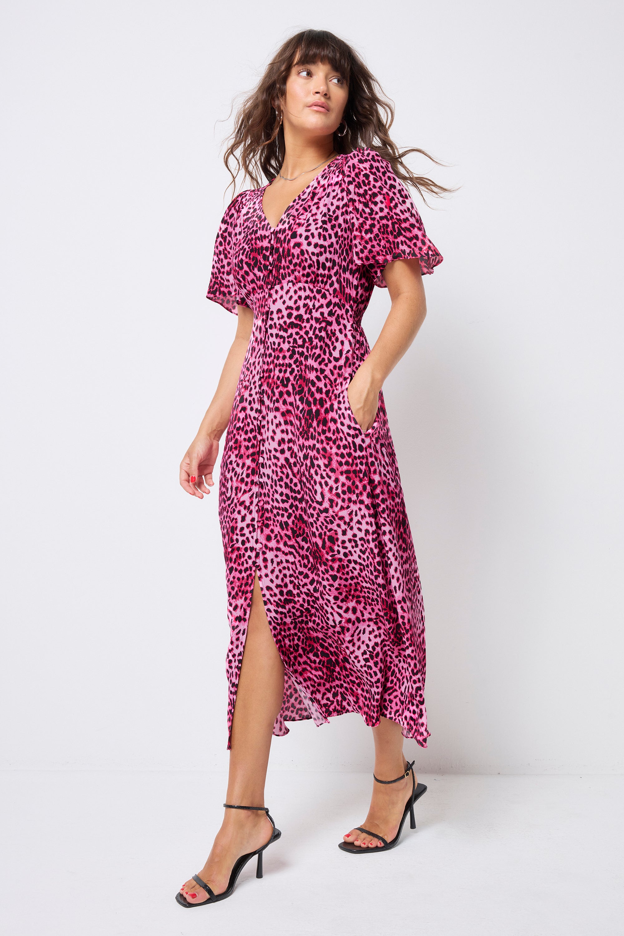 Scamp and Dude Navy Long Sleeve Jumper | Model wearing a pink cheetah angel sleeve tea dress in a midi length with black strappy heels.