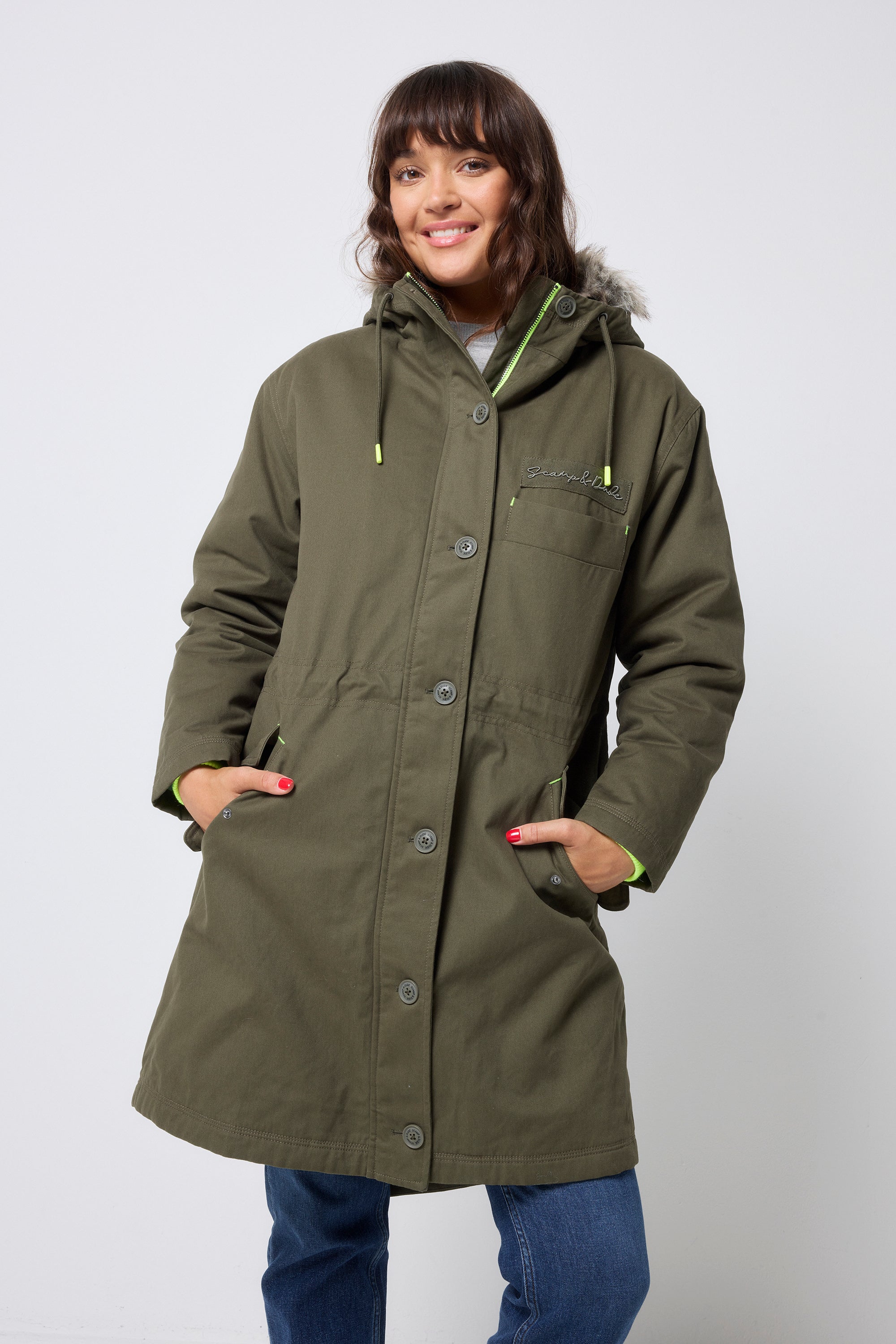 Scamp and Dude Khaki Parka | Model wearing a khaki parka jacket with blue jeans and a grey sweatshirt.
