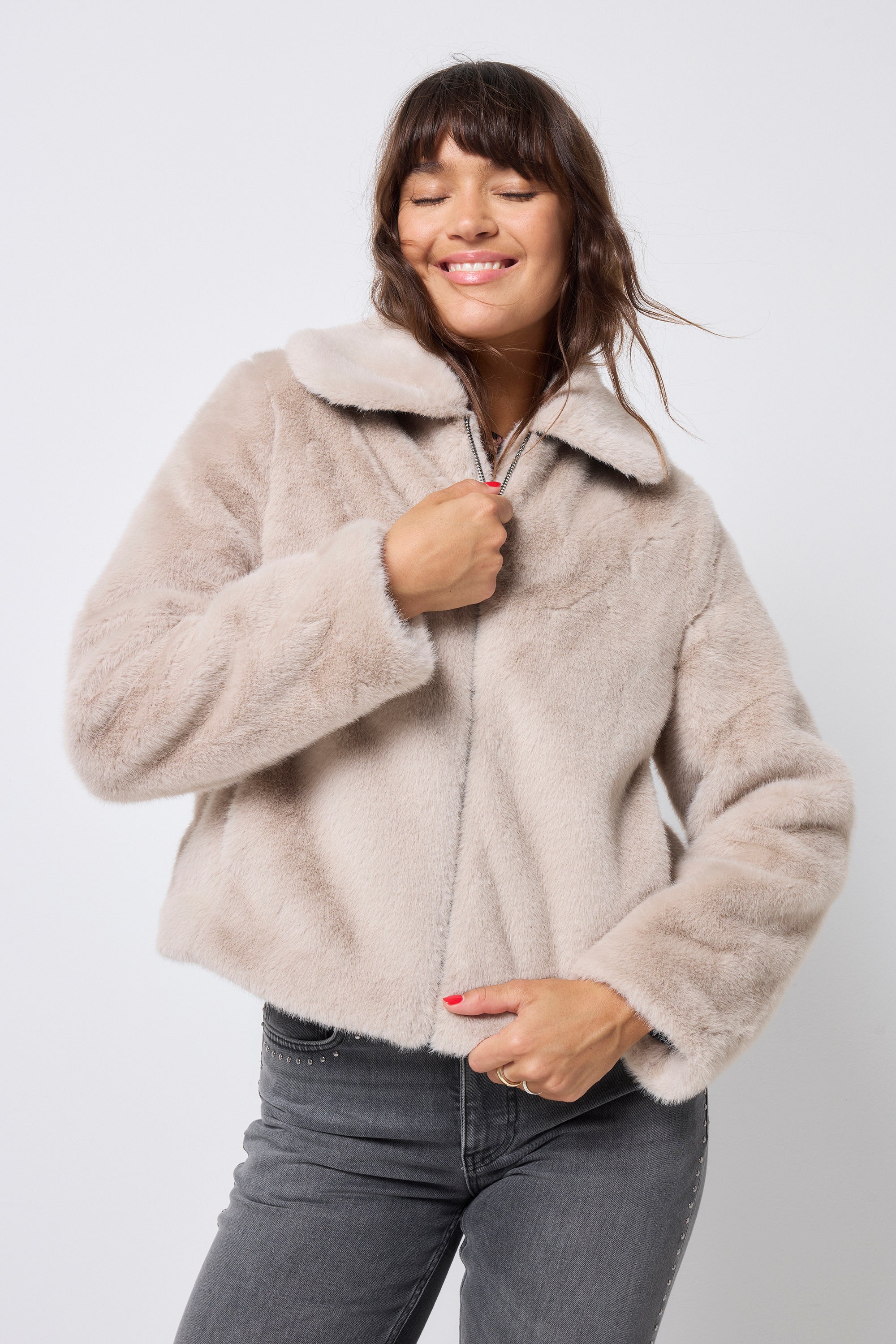 Scamp and Dude Cream Faux Fur Jacket | Model wearing washed black jeans with a faux fur jacket and neutral cheetah print top.