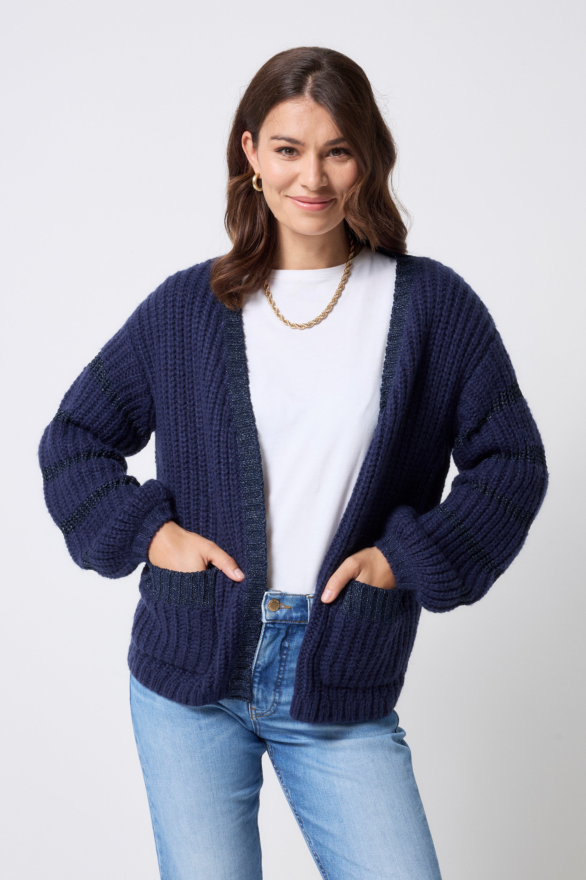 Scamp and Dude Navy Lurex Stripe Edge to Edge Cardigan | Model wearing a pair of light blue jeans with a white t-shirt and navy cardigan featuring lurex detail.