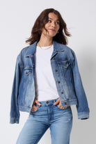 Scamp and Dude Indigo Blue Trucker Denim Jacket | Model wearing a white t-shirt with a pair of blue jeans and a blue denim jacket.