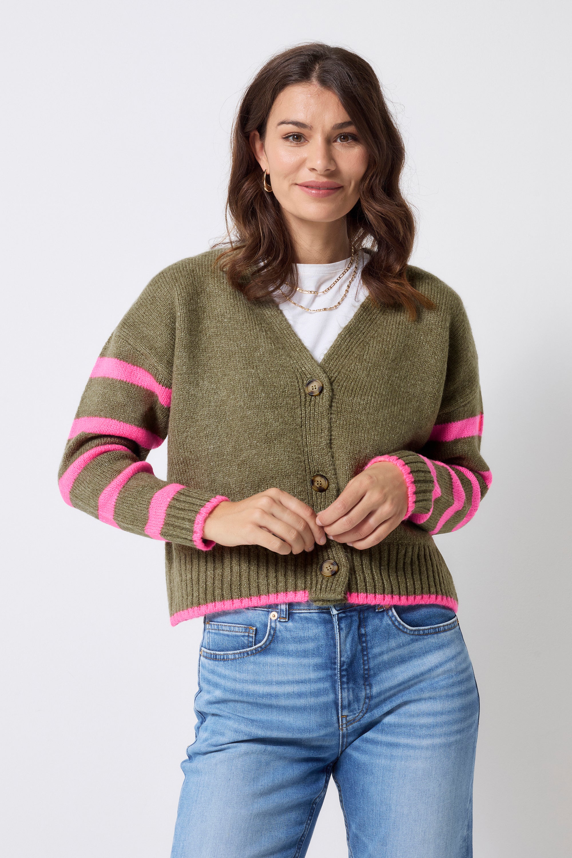 Scamp and Dude Khaki and Pink Stripe Cardigan | Model wearing a pair of blue denim jeans with a white-shirt, khaki and pink stripe cardigan and gold jewellery.
