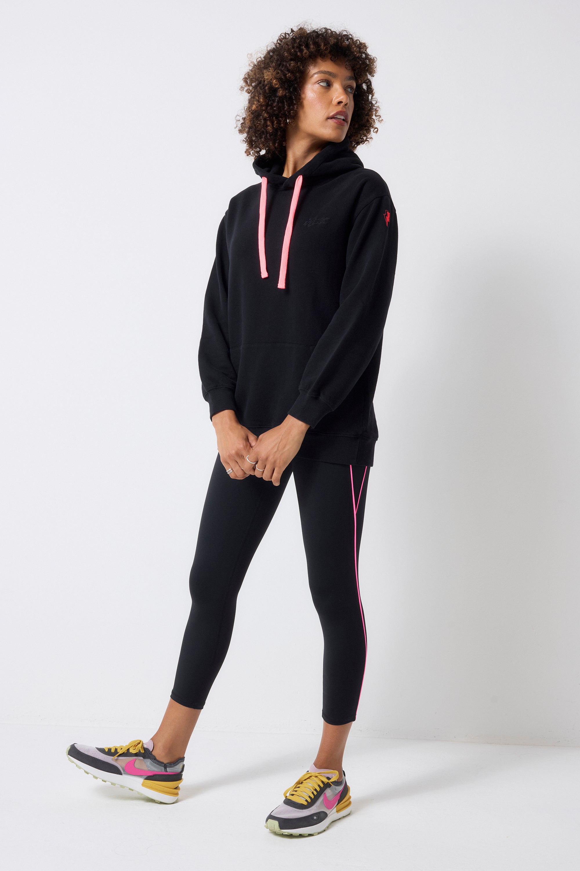 Scamp and Dude Black with Neon Piping 7/8 Length Active Leggings | Model wearing black leggings with a longline black hoodie.