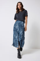 Scamp and Dude Navy Cheetah Midi Skirt | Model wearing a dark grey studded t-shirt with a navy blue cheetah print skirt and black boots.