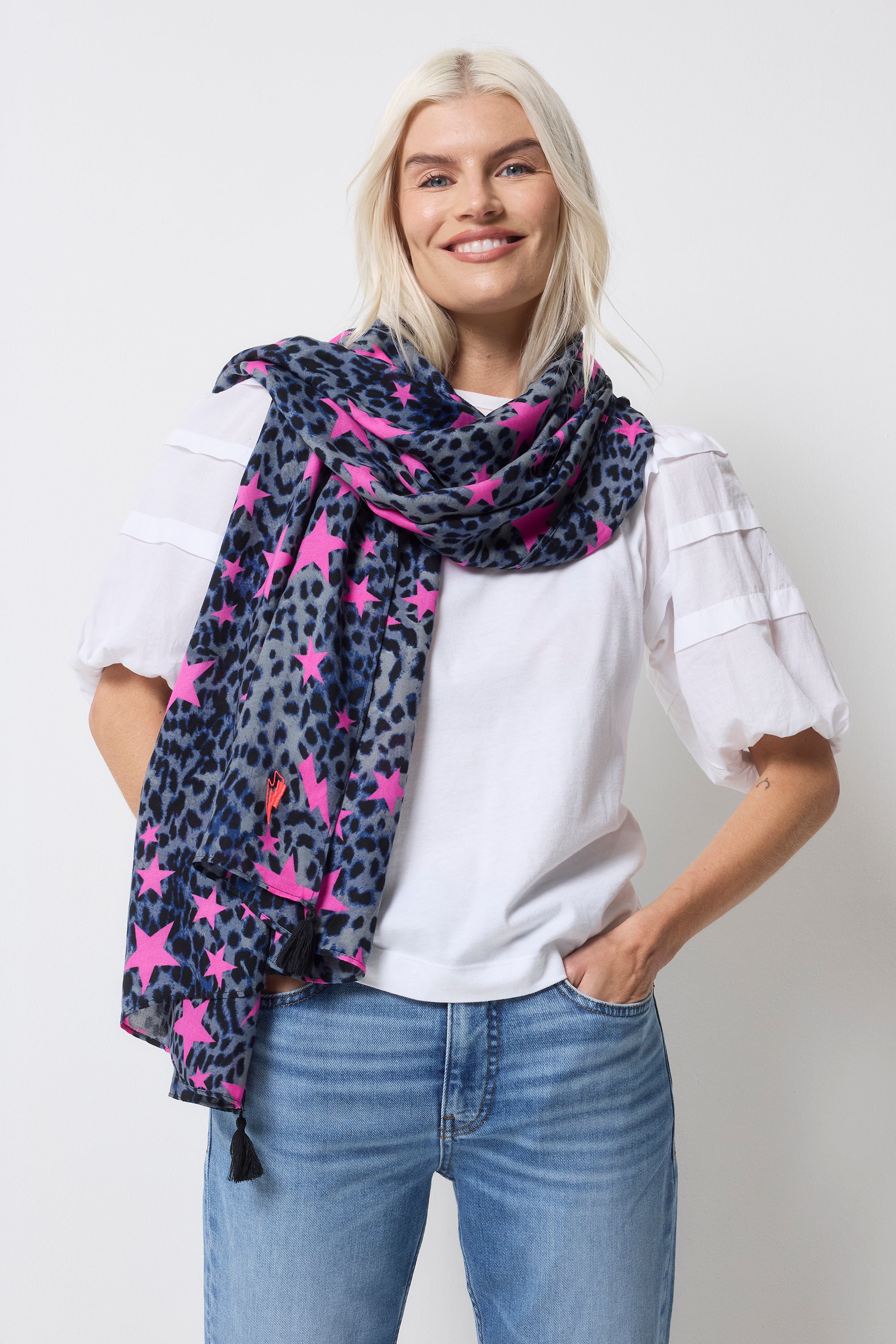 Scamp and Dude Navy with Pink Star Cheetah Charity Super Scarf | Model wearing a white t-shirt with a pair of light blue jeans and a navy with pink star cheetah print super scarf.