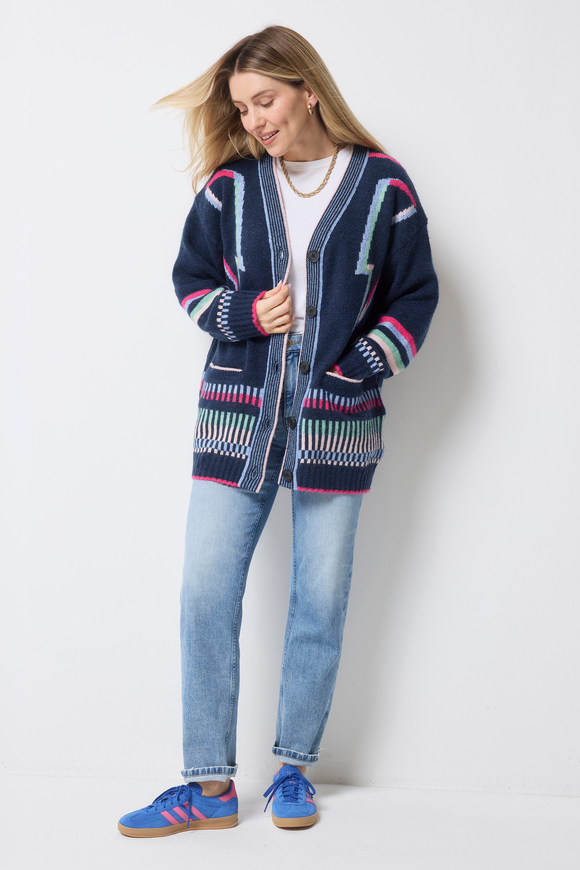Scamp and Dude Navy with Rainbow Statement Bolt Longline Cardigan | Model wearing a navy longline cardigan featuring rainbow bolt detail with blue jeans and a white t-shirt.