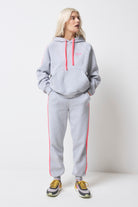 Scamp and Dude Light Grey Marl with Pink Colourblock Joggers | Model wearing light grey hoodie featuring a neon pink stripe and drawstring with matching joggers.