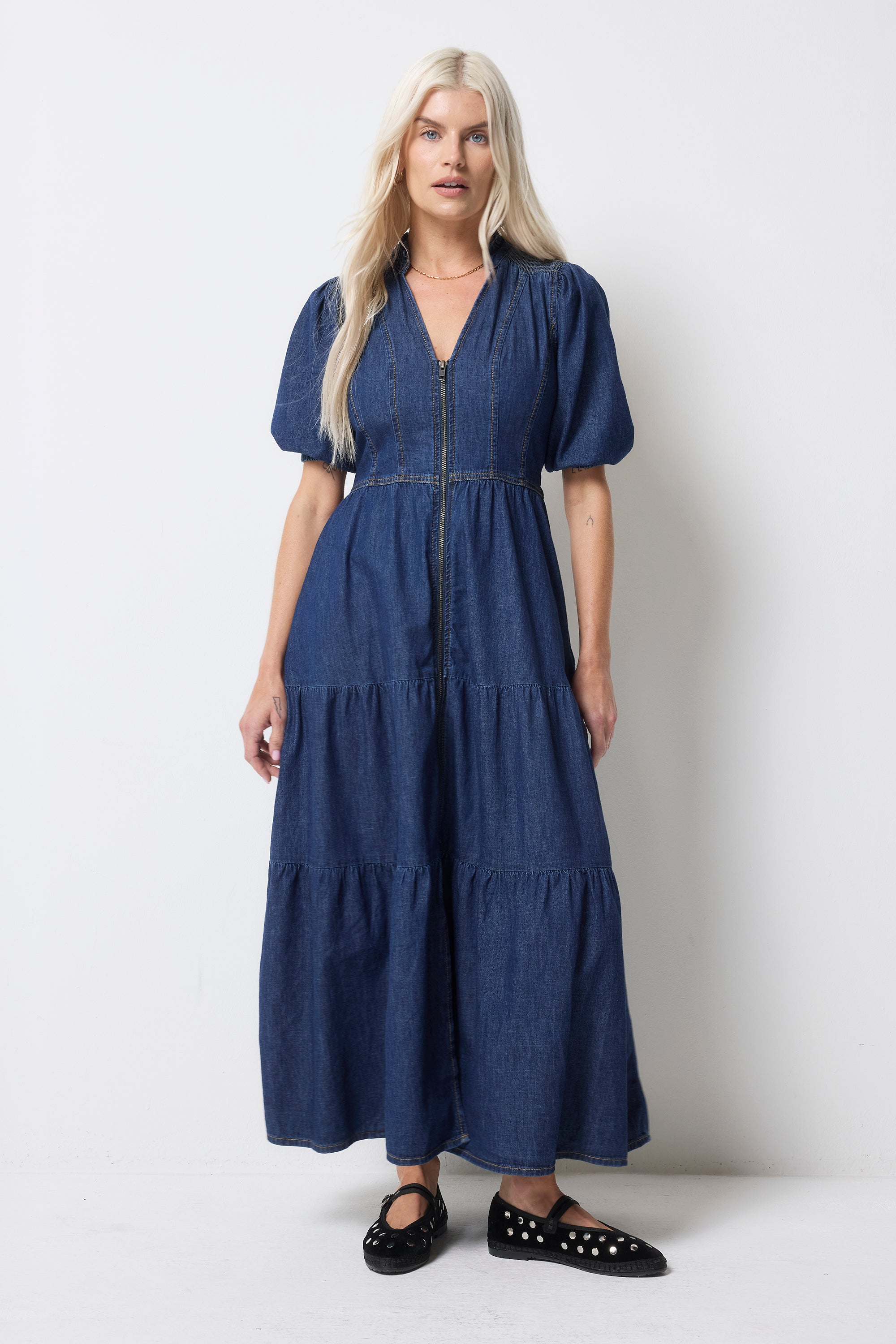 Scamp and Dude Authentic Indigo Zip Detail Tiered Midi Denim Dress | Model wearing a blue denim dress with zip front detail. Worn with black studded pumps.