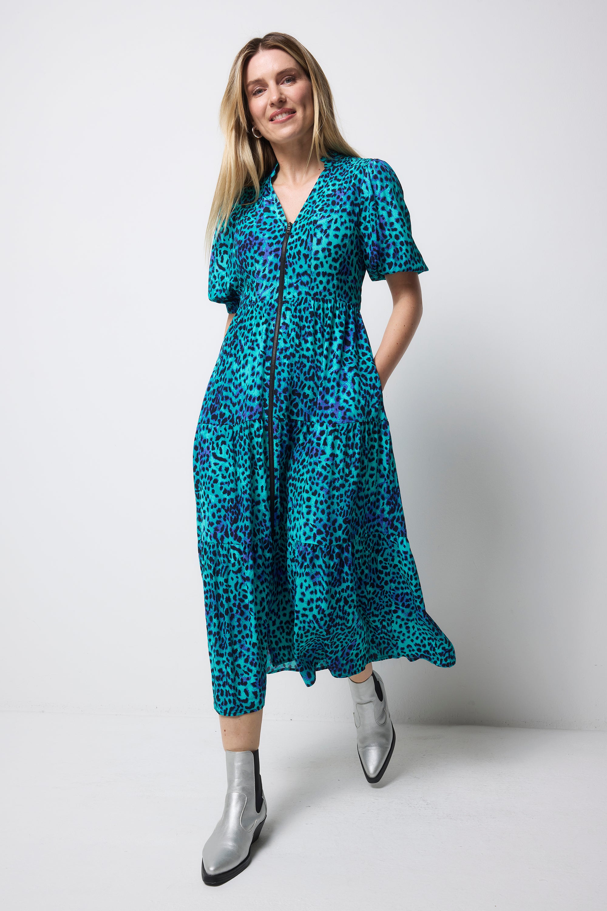 Scamp and Dude Turquoise with Blue Cheetah Zip Front Midi Tiered Dress | Model wearing a turquoise cheetah print midi zip front dress with silver boots.
