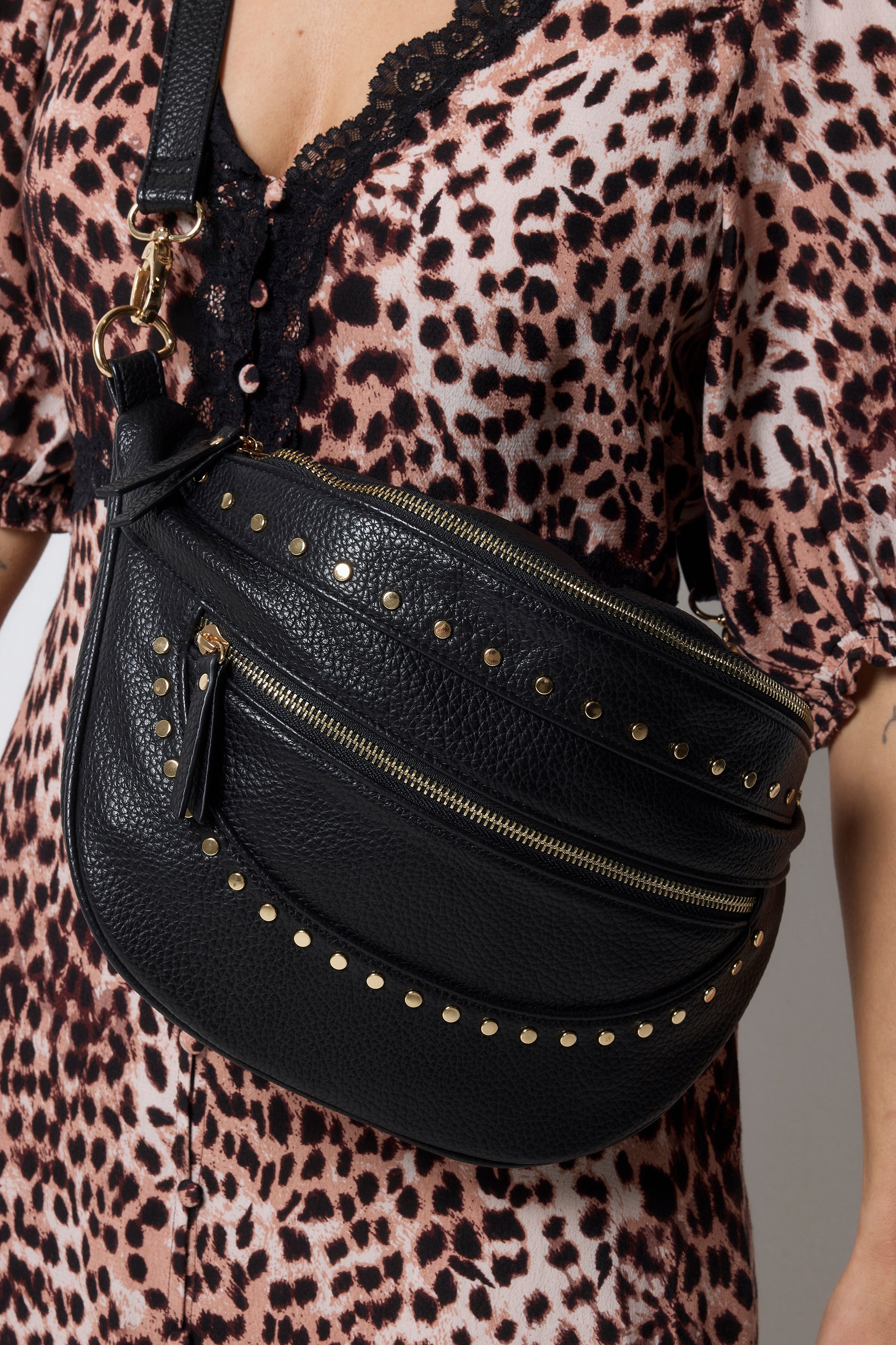 Scamp and Dude Black Studded Bum Bag | Model wearing a neutral cheetah print dress with a black bum bag that features gold stud detail.