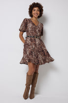 Scamp and Dude Neutral with Black Cheetah Short Skater Tea Dress | Model wearing a short neutral cheetah print dress in a skater style with brown knee high boots.