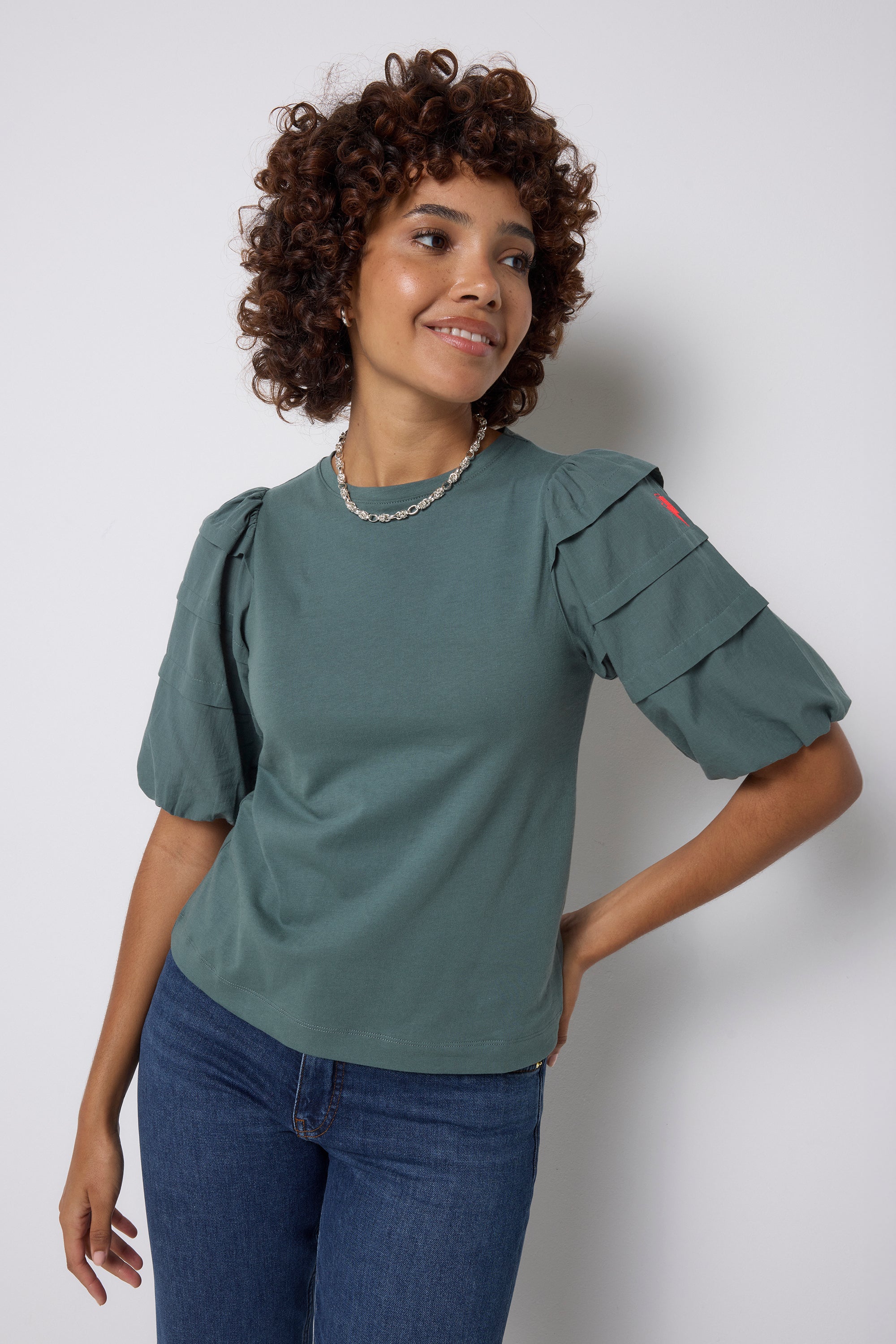 Scamp and Dude Khaki Pintuck Sleeve T-Shirt | Model wearing a pair of indigo jeans with a khaki pintuck sleeve t shirt.