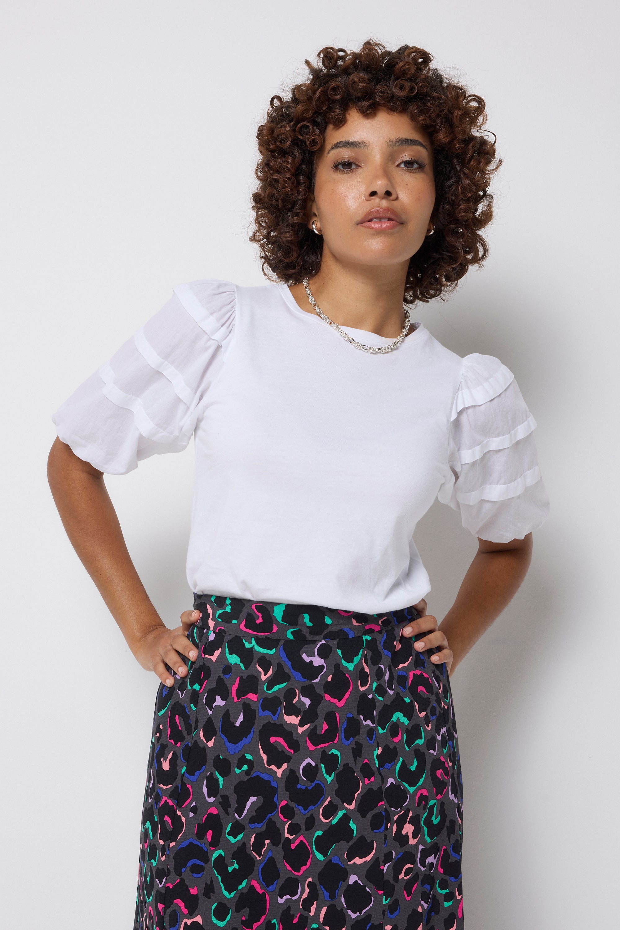 Scamp and Dude White Pintuck Sleeve T-Shirt | Model wearing a rainbow leopard print skirt with a white t shirt.