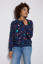 Scamp and Dude Navy with Rainbow Snow Leopard Oversized Sweatshirt | Model wearing dark navy jumper with rainbow snow leopard print. Worn with light blue denim jeans.
