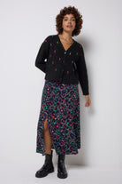 Scamp & Dude Grey with Rainbow Ziggy Leopard Split Front Skirt | Model wearing a black cardigan featuring neon flecks and a patterned skirt with black chunky boots.