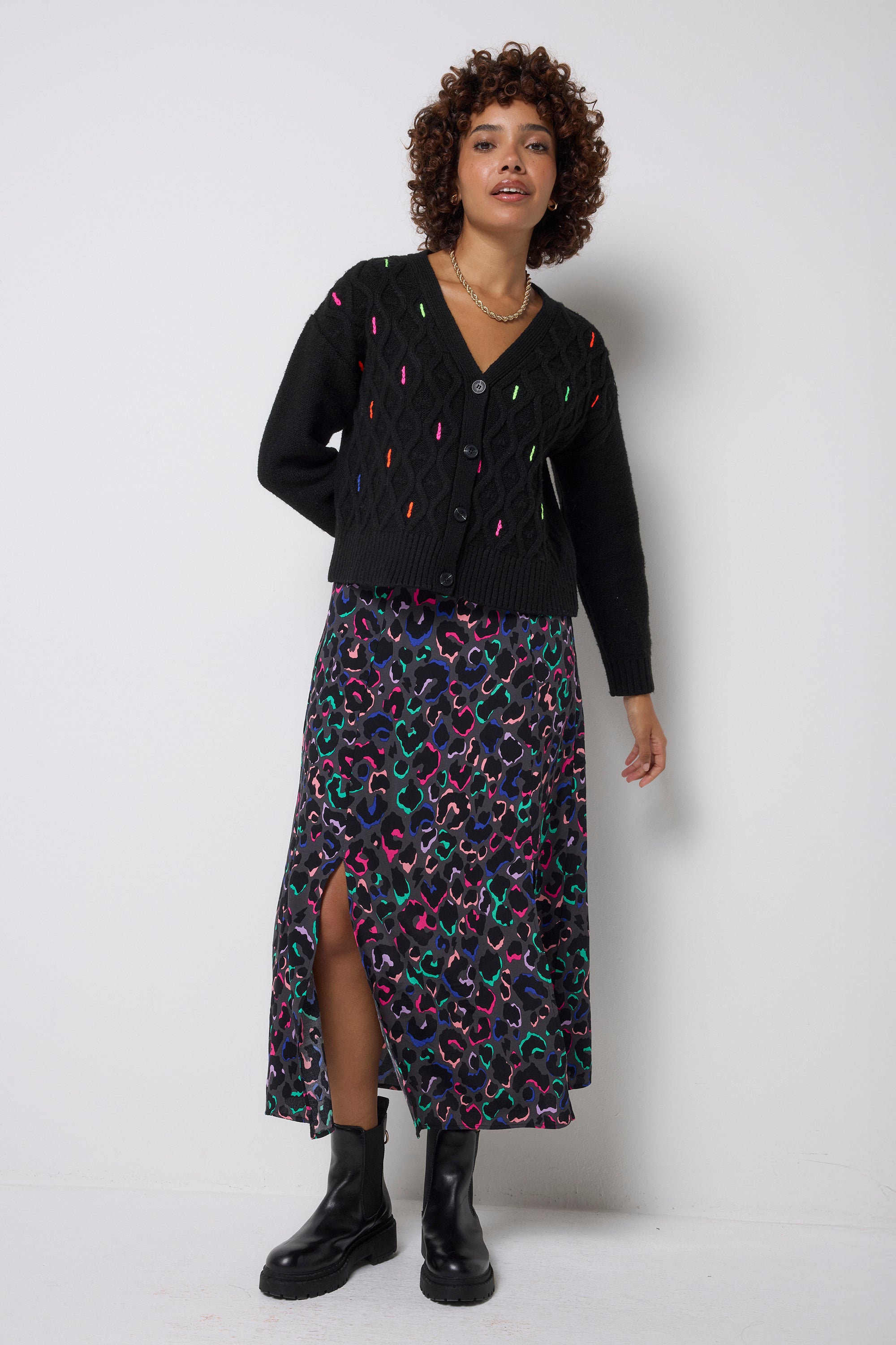 Scamp & Dude Grey with Rainbow Ziggy Leopard Split Front Skirt | Model wearing a black cardigan featuring neon flecks and a patterned skirt with black chunky boots.