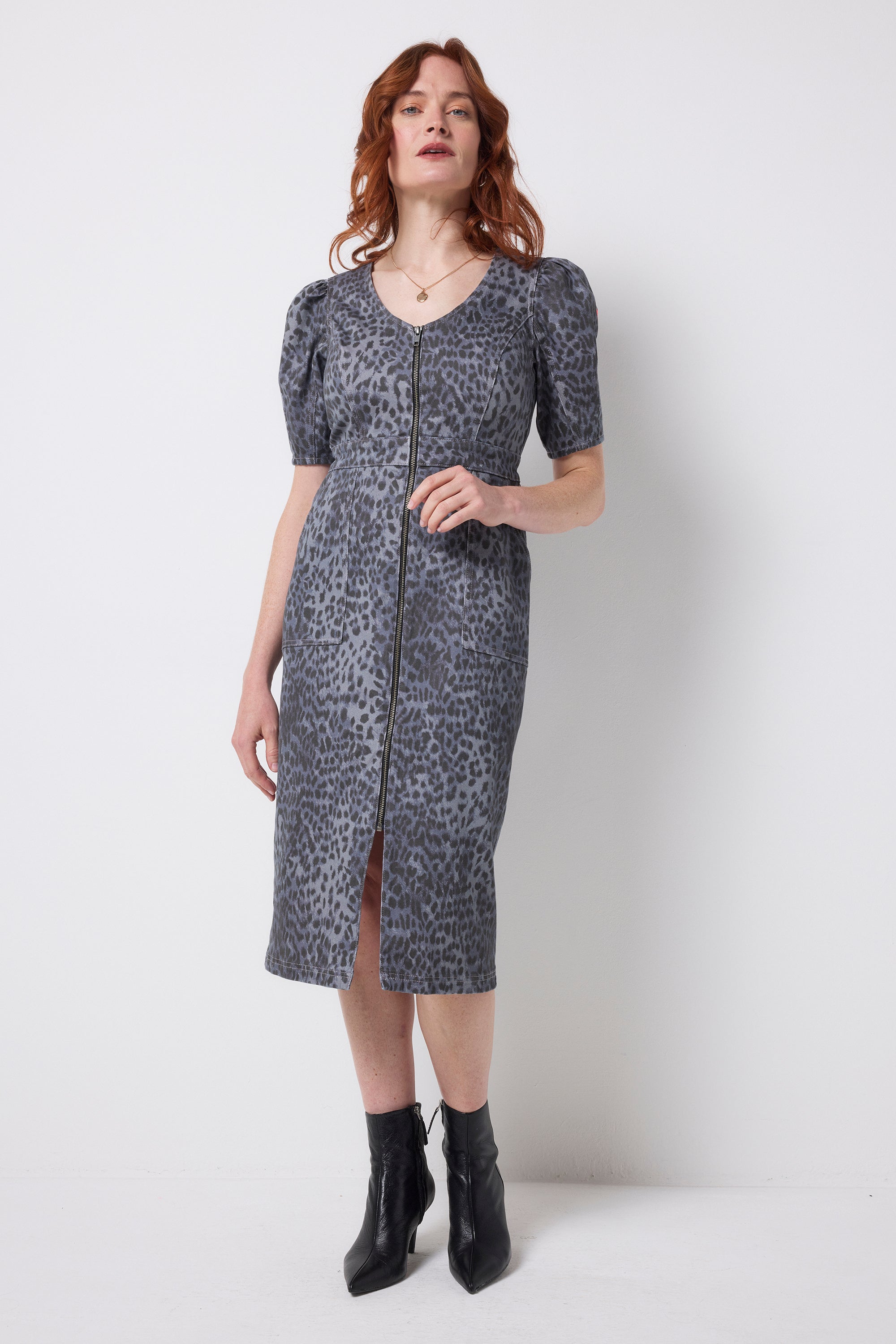 Scamp and Dude Washed Navy Wild Cheetah Denim Zip Front Midi Dress | Model wearing a washed navy cheetah print denim dress with zip front detail. Worn with black heeled boots.