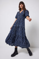 Scamp & Dude Navy Jaguar Shirred Zip Detail Midi Dress | Model wearing a blue zip front jaguar print dress with black boots on a white background