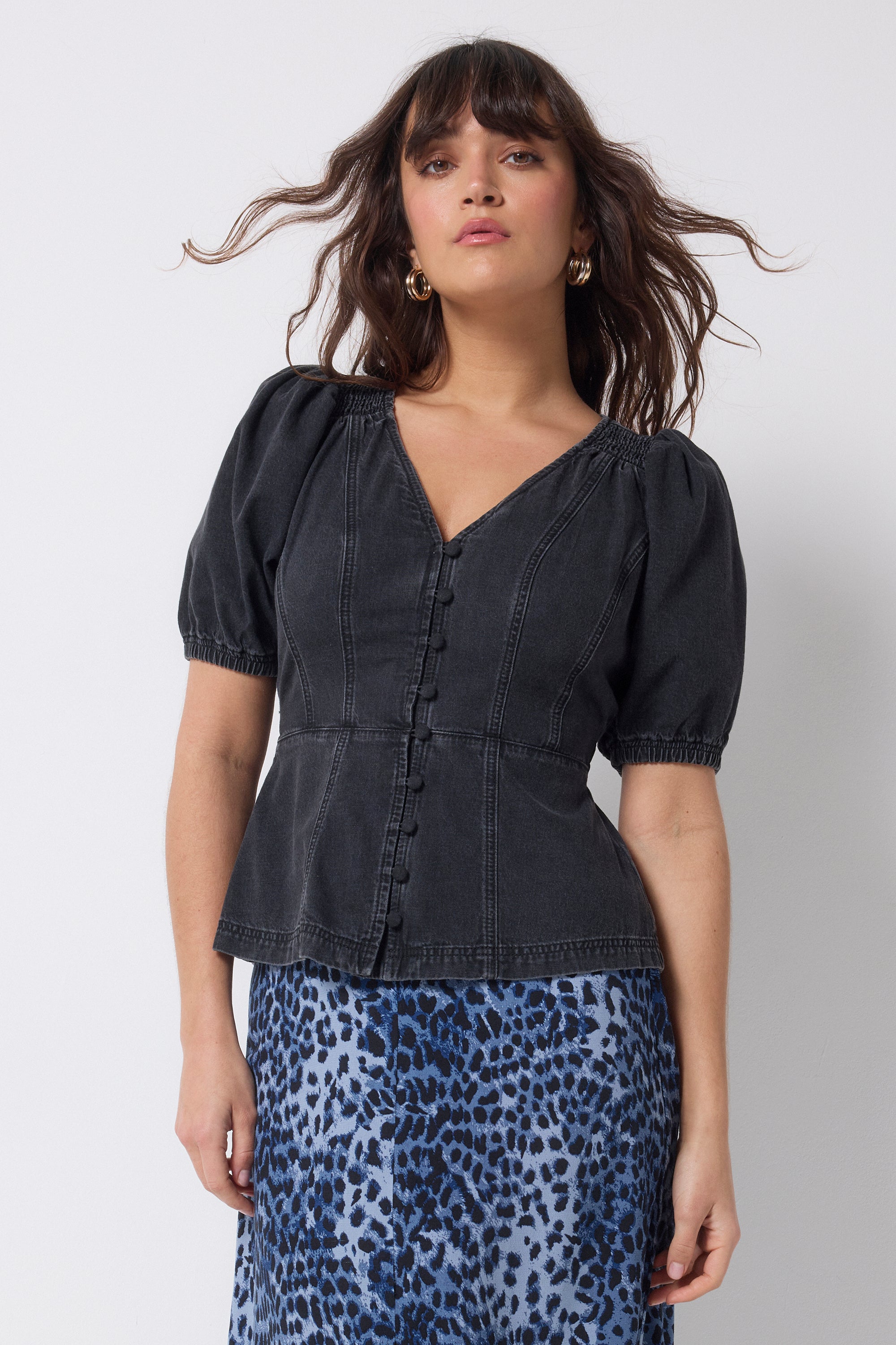 Scamp and Dude Washed Black Button Through Denim Top | Model wearing a black denim button front top with a navy cheetah print midi skirt.