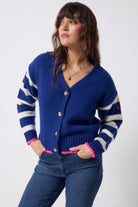 Scamp and Dude Bright Blue with Cream Stripe Cardigan | Model wearing a bright blue cardigan with cream stripe and pink detail.