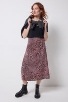 Scamp and Dude Neutral Leopard Ray Midi Slip Skirt | Model wearing a neutral leopard ray print skirt with a black v-neck t-shirt and black boots.