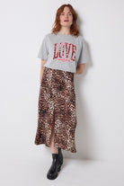 Scamp and Dude Grey Marl Love Cheetah T-Shirt | Model wearing a neutral cheetah print skirt with a grey t-shirt featuring love cheetah print.