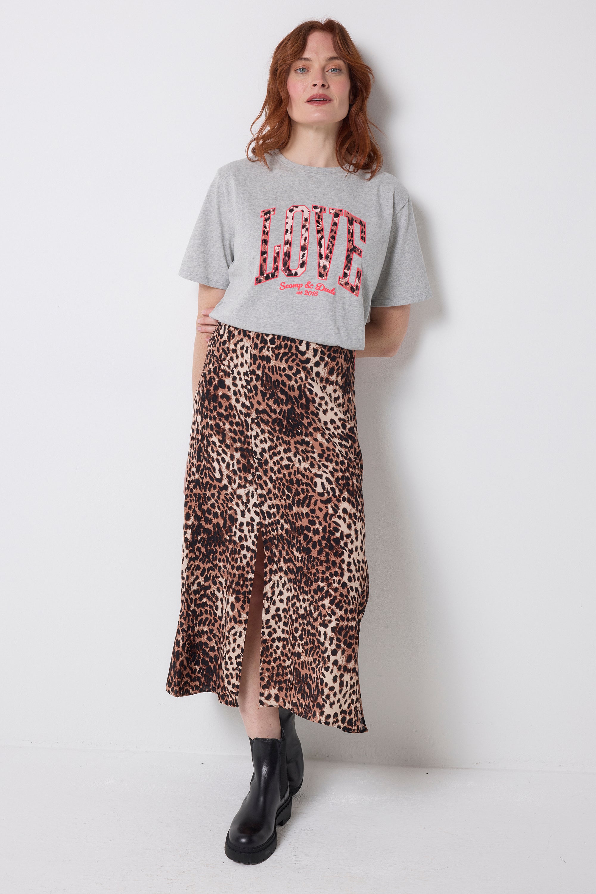 Scamp and Dude Grey Marl Love Cheetah T-Shirt | Model wearing a neutral cheetah print skirt with a grey t-shirt featuring love cheetah print.