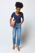 Scamp and Dude Navy V-Neck T-Shirt | Model wearing dark navy v-neck t-shirt with a pair of blue boyfriend jeans and gold heels.