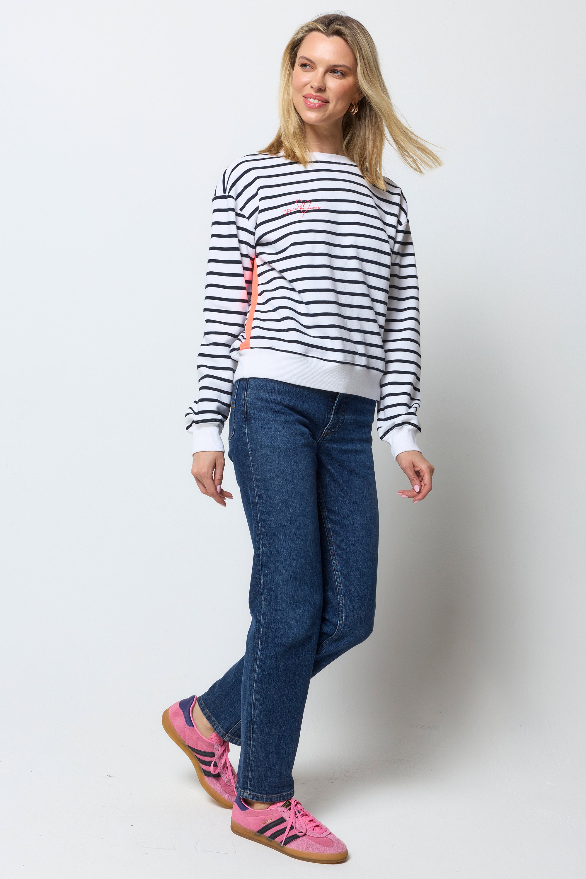 Scamp & Dude Navy and Ecru Stripe Colourblock Ultimate Sweatshirt | Model wearing a striped sweatshirt, blue jeans and pink trainers on a white background.