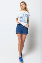 Scamp and Dude Ecru Tile Print T-Shirt | Model wearing an ecru tile print t-shirt with blue denim shorts and blue trainers.