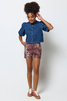 Scamp & Dude Neutral Cheetah Patch Pocket Denim Shorts | Model wearing a denim shirt and leopard print shorts on a white background.