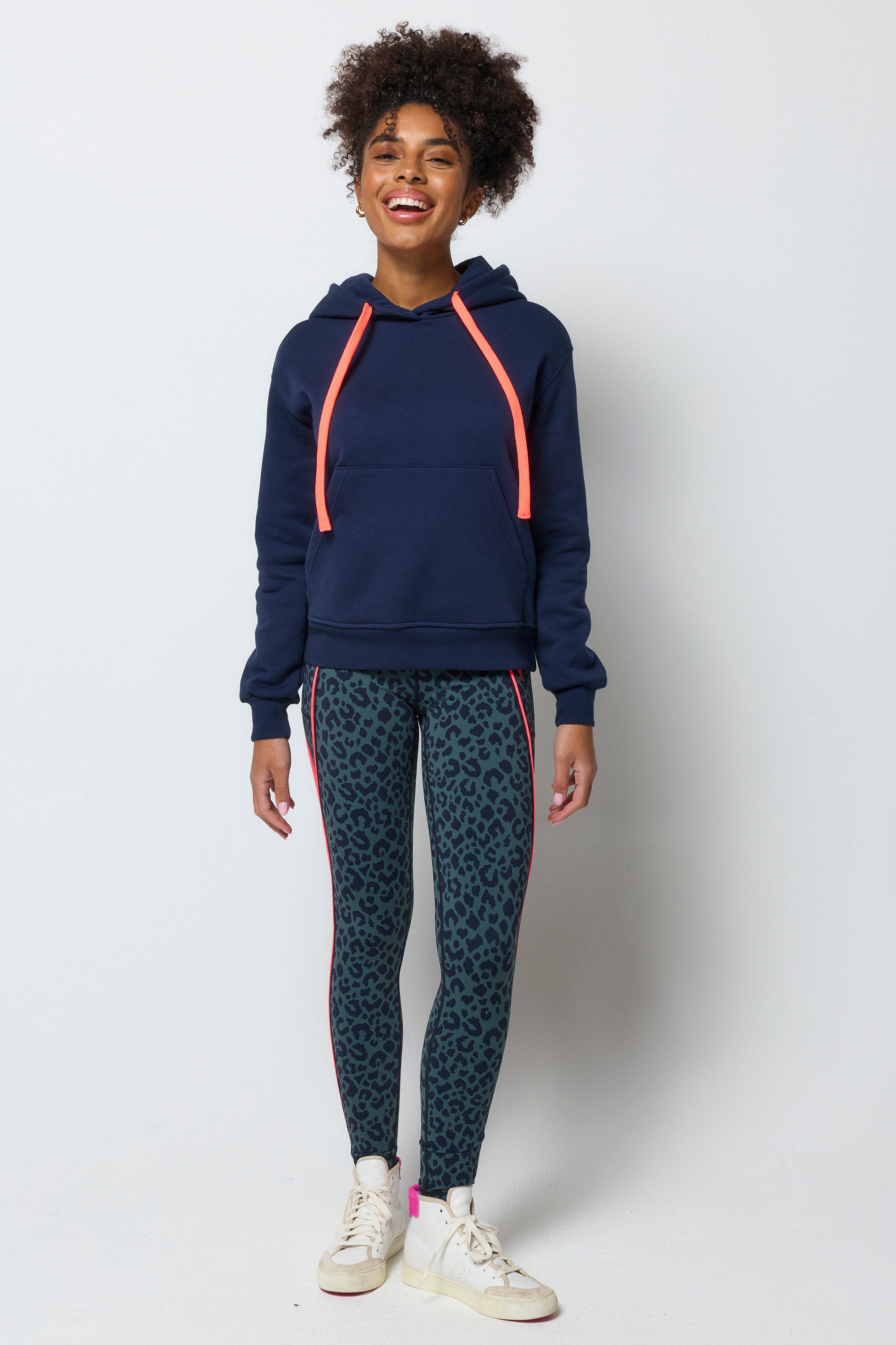 Scamp and Dude Navy Embroidered Logo Ultimate Hoodie | Model wearing dark navy hoodie with embroidered Scamp & Dude logo on the back. Worn with khaki leopard print leggings.