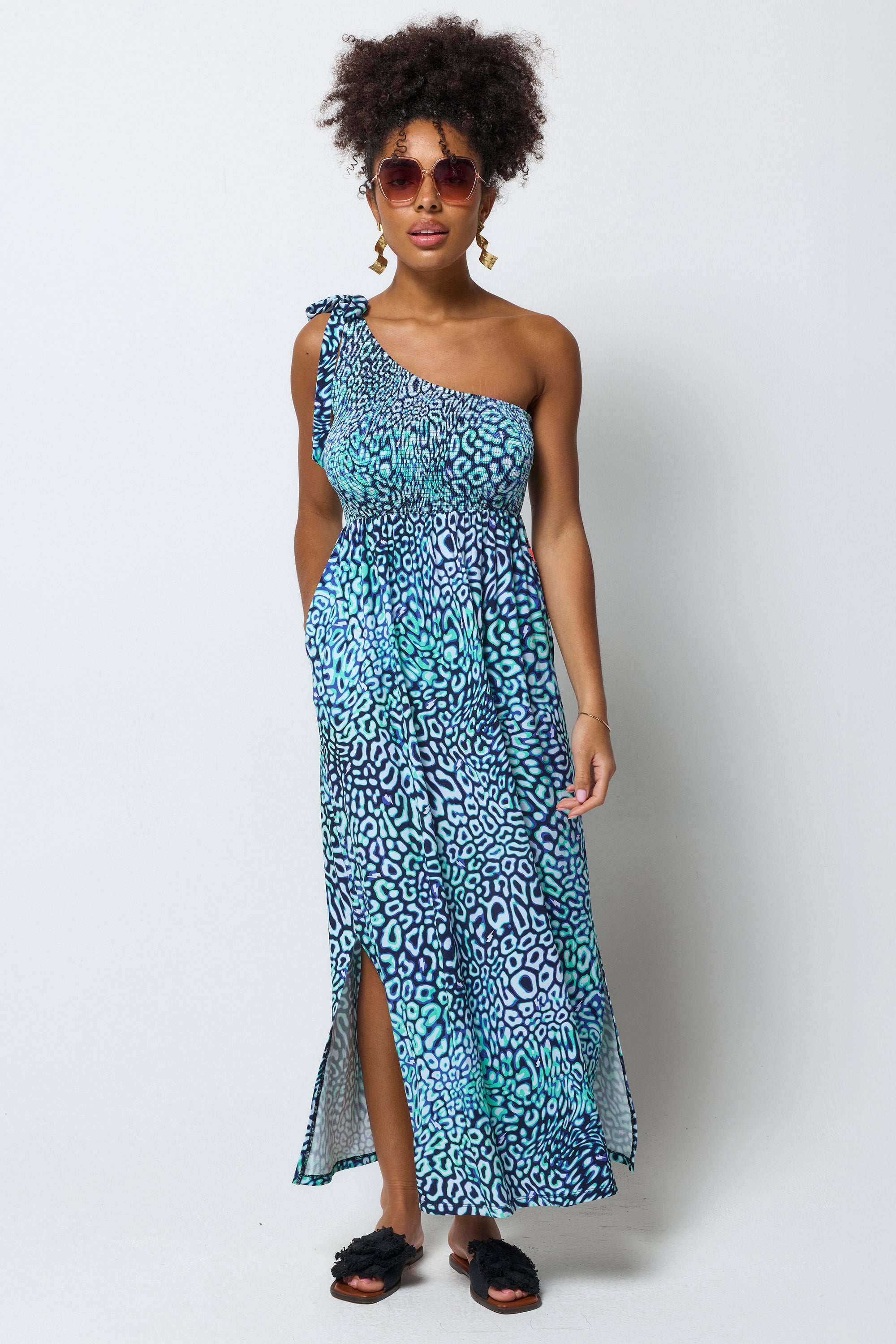 Scamp and Dude Green Leopard Ray One Shoulder Maxi Dress | Model wearing a green one shoulder maxi dress in a leopard ray print. Worn with black sandals.