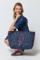 Scamp and Dude Navy Jaguar Canvas Shopper Bag | Model wearing a frill denim dress with blue trainers and a navy canvas shopper bag.