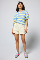 Scamp & Dude Lemon Scallop Denim Shorts | Model wearing a pair of yellow denim scallop shorts with a stripe short sleeve cardigan.