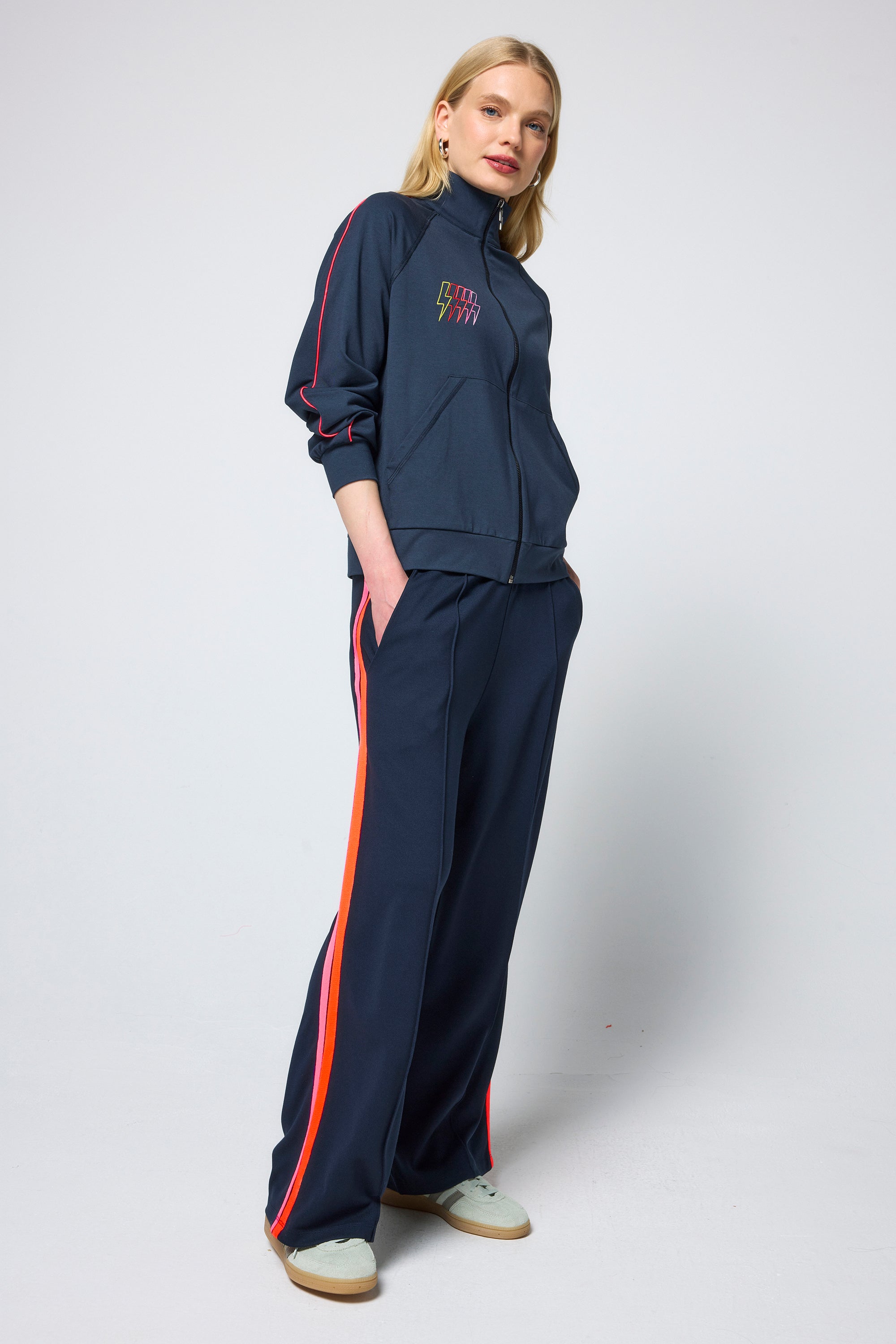 Scamp and Dude Navy Funnel Neck Zip Through Top | Model wearing navy tunnel neck top with matching joggers.