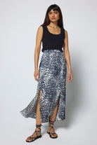 Scamp & Dude Grey with White and Black Cheetah Split Front Skirt | Model wearing a black sleeveless top and cheetah print midi skirt on a white background.