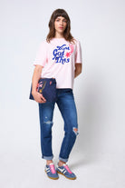 Scamp & Dude Scamp & Dude x Maggie's Pink 'You Got This!' Charity T-Shirt | Model wearing a pink t-shirt with you got this graphic print, blue jeans, and colourful trainers.