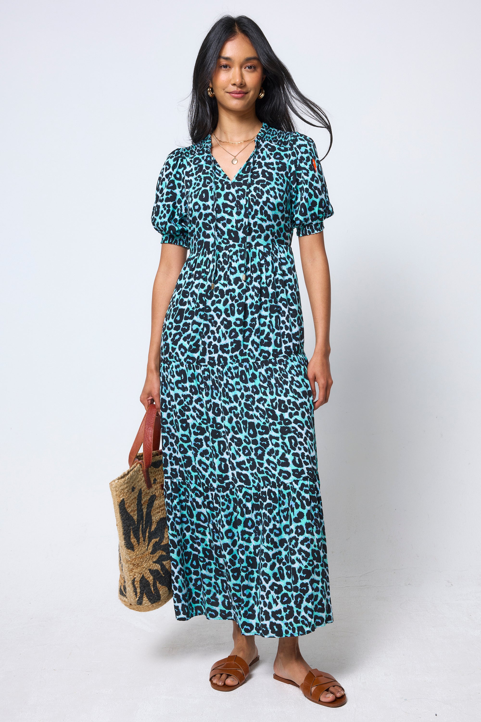Scamp & Dude Mint Jaguar Tie Front Maxi Dress | Model wearing a mint green jaguar print dress holding a woven bag with brown sandals.