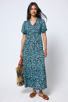 Scamp & Dude Mint Jaguar Tie Front Maxi Dress | Model wearing a mint green jaguar print dress holding a woven bag with brown sandals.
