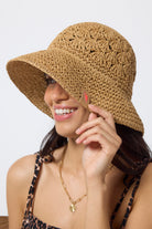 Scamp & Dude Natural Straw Bucket Hat | Model wearing a neutral jaguar strappy jumpsuit with a straw bucket hat.
