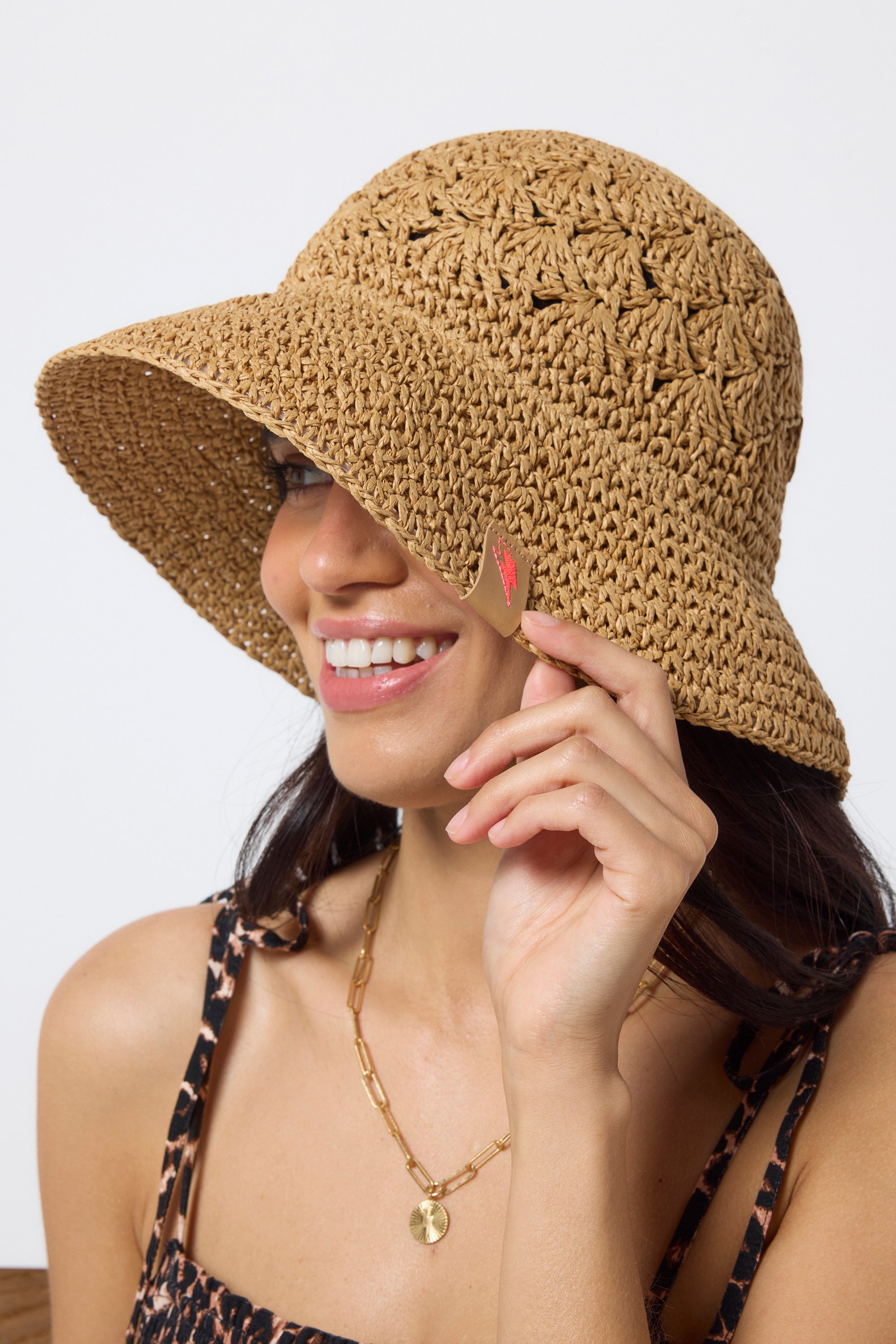 Scamp & Dude Natural Straw Bucket Hat | Model wearing a neutral jaguar strappy jumpsuit with a straw bucket hat.