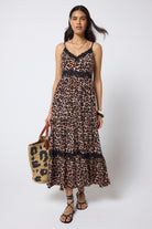 Scamp & Dude Neutral Jaguar Lace Trim Midi Sundress | Model wearing a neutral jaguar print sundress with delicate black lace trim detail. Worn with black flat sandals and a straw bag.