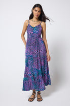 Scamp & Dude Pink with Green Leopard Ray Pintuck Midi Sundress | Model wearing a pink, purple and green patterned dress with black flat sandals.