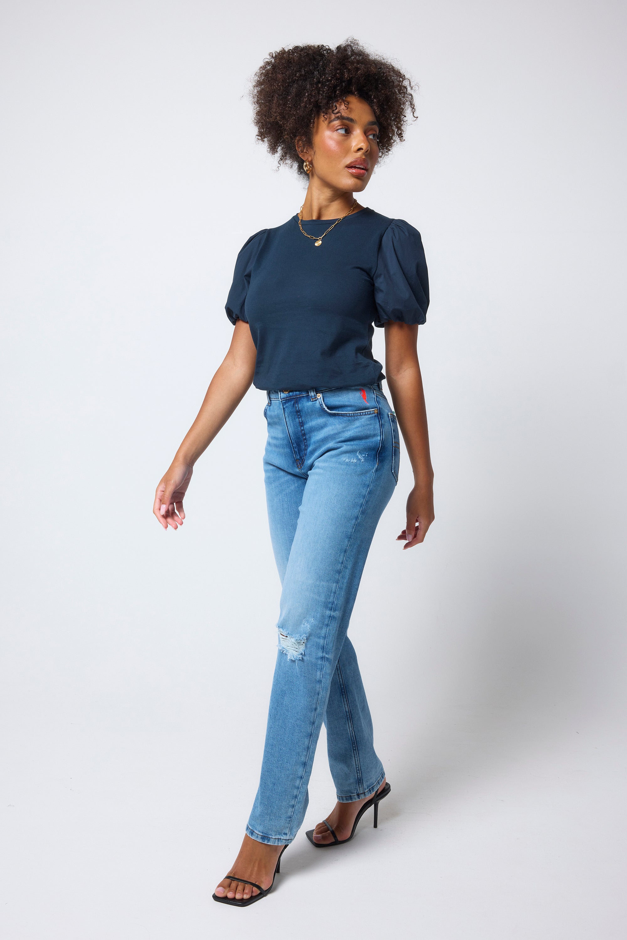 Scamp & Dude Navy Puff Sleeve T-Shirt | Model wears a navy puff sleeve t-shirt with distressed jeans and black high heels.