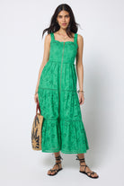 Scamp and Dude Green Broderie Zip Detail Midi Sundress | Model wearing a green broderie zip front midi dress with black sandals and sunglasses, holding a sun print straw bag.