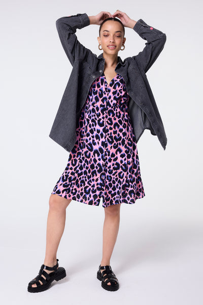 Scamp and Dude Washed Black Oversized Denim Shirt | Model wearing a washed black denim shirt in an oversized fit, layered over a pink and blue shadow leopard print dress.